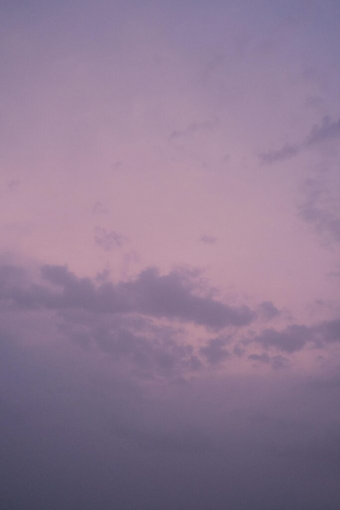Beautiful purple twilight sky with scattered clouds, perfect for serene backgrounds.