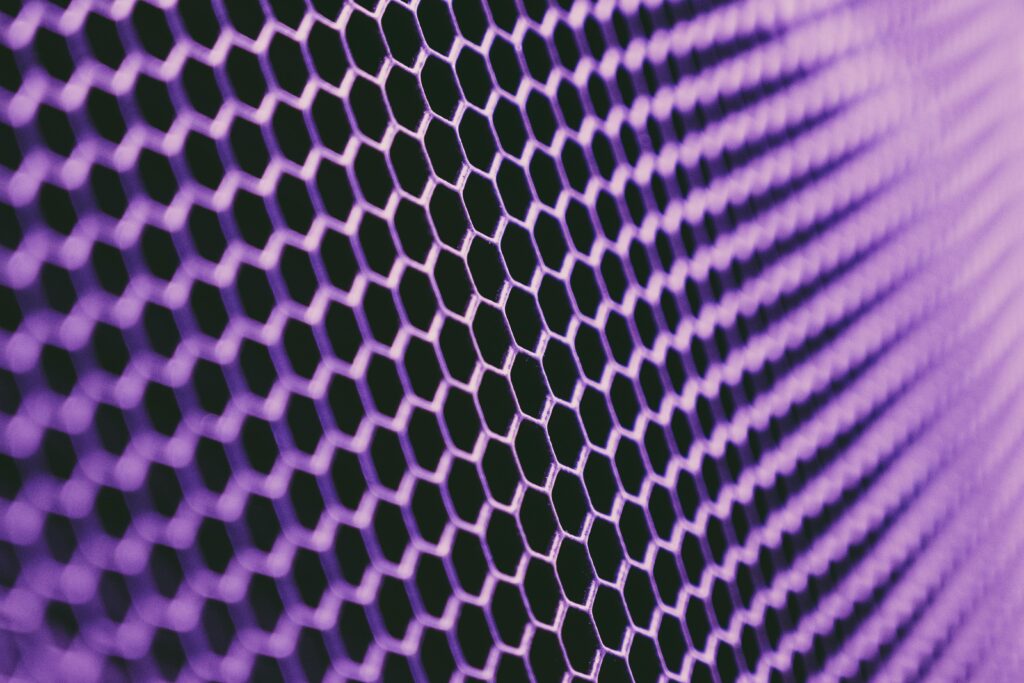A close-up view of a vibrant purple hexagonal grid pattern, providing a modern metallic texture.